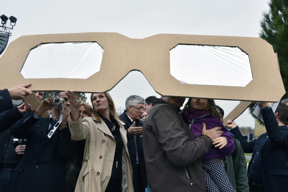 <p>People use giant protective glasses to watch a solar eclipse on March 20, 2015 at the City de l’Espace (Space City) in Toulouse, France. (Photo: Pascal Pavani/AFP/Getty Images) </p>