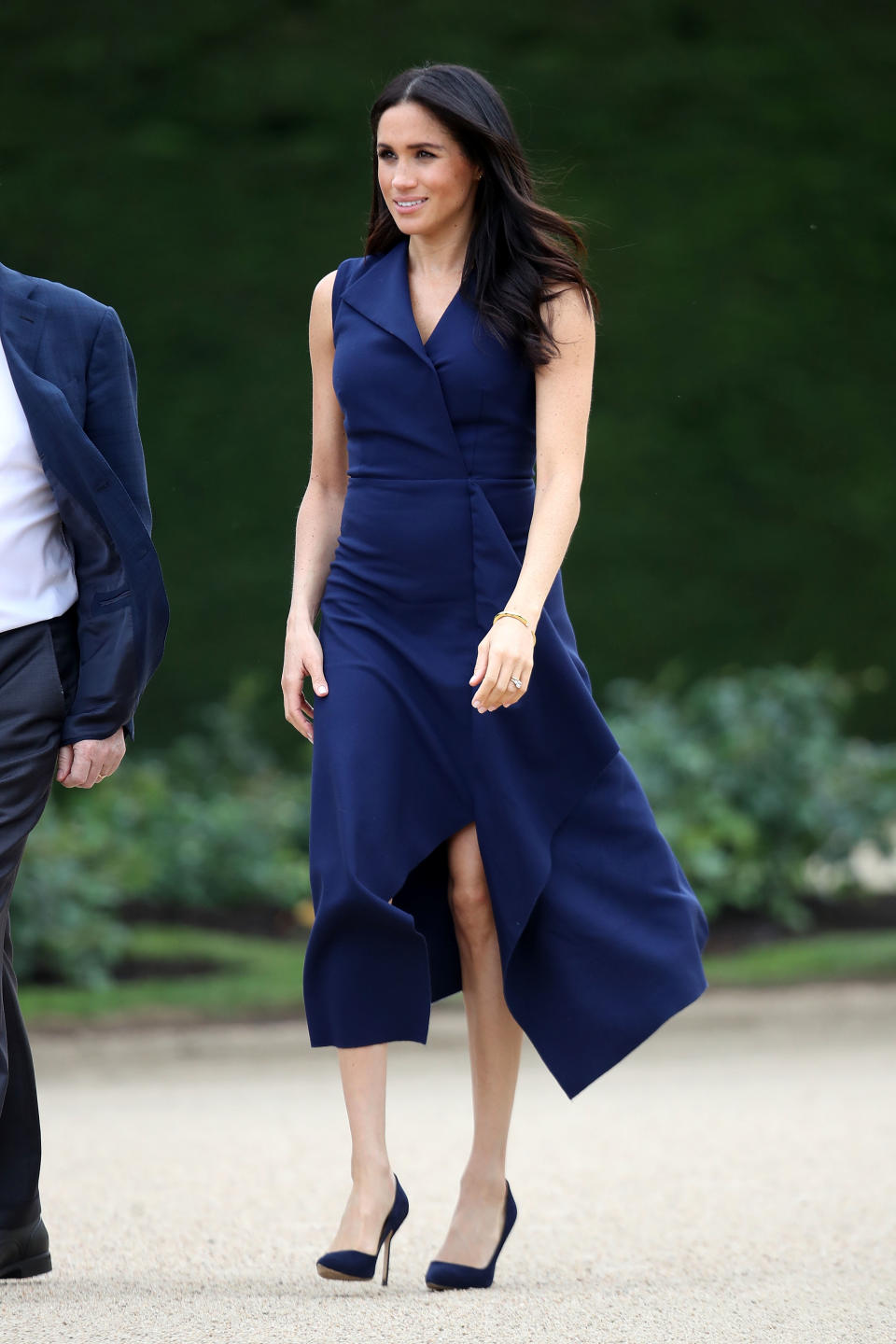 <p>Meghan wore a custom-made navy blue dress by Australian designer Dion Lee for a reception at Government House Victoria. She accessorised with a pair of Manolo Blahnik ‘BB’ shoes and a Shaun Leanne ‘Tusk’ diamond bracelet. <em>[Photo: Getty]</em> </p>