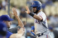 Texas Rangers' Isiah Kiner-Falefa gets a high-five after scoring on a double by Adolis Garcia against the Los Angeles Dodgers during the third inning of a baseball game in Los Angeles on Saturday, June 12, 2021. (AP Photo/Alex Gallardo)