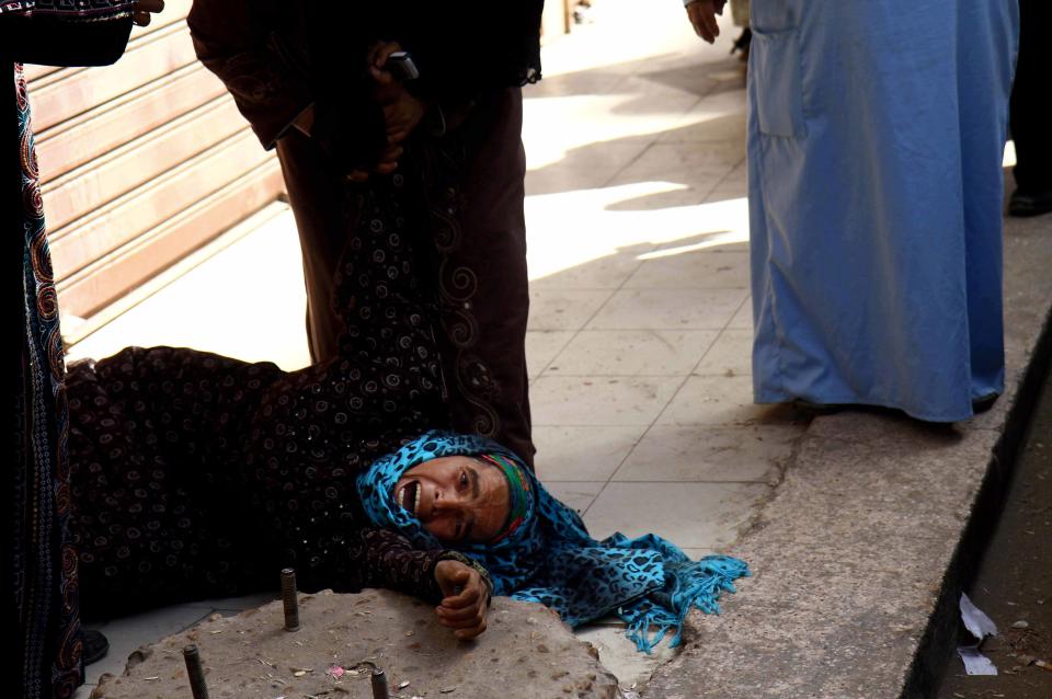 An Egyptian woman overcome by emotion weeps after a judge sentenced to death more than 680 alleged supporters of the country’s ousted Islamist president over acts of violence and the murder of policemen in the latest mass trial in the southern city of Minya, Egypt, Monday, April 28, 2014. Attorney Ahmed Hefni told reporters outside the court in Minya on Monday that the death sentences first have to be approved by Egypt's mufti, the top Islamic official — a step that is usually considered a formality. (AP Photo/Ahmed Gomaa)