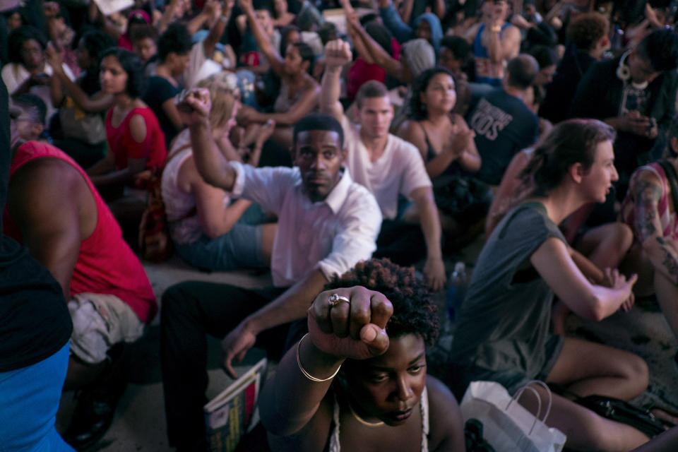 FILE - In this July 14, 2013, file photo, marchers raise their fists as they sit down in New York's Times Square, for a protest against the acquittal of volunteer neighborhood watch member George Zimmerman in the 2012 killing of 17-year-old Trayvon Martin in Sanford, Fla. The Black Lives Matter movement emerged amid anger over the acquittal of Zimmerman. (AP Photo/Craig Ruttle)