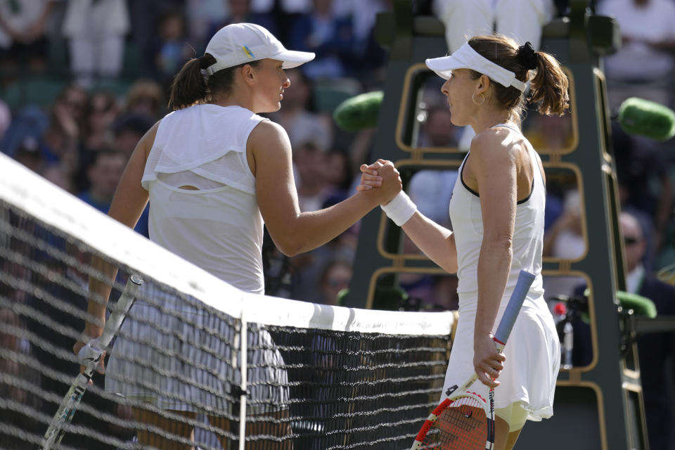 France's Alize Cornet, right, shakes hands with Poland's Iga Swiatek after defeating her in a third round women's singles match on day six of the Wimbledon tennis championships in London, Saturday, July 2, 2022. (AP Photo/Kirsty Wigglesworth)