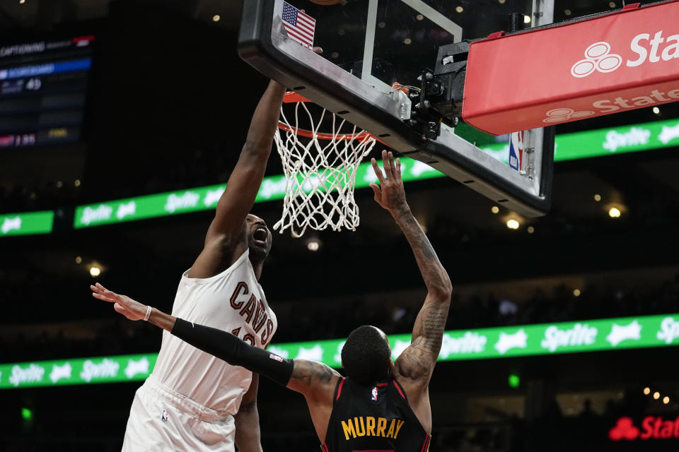 Atlanta Hawks' Dejounte Murray, right, shoots and scores against Cleveland Cavaliers center Tristan Thompson (13) during the first half of an NBA basketball game, Saturday, Jan. 20, 2024, in Atlanta. (AP Photo/Brynn Anderson)