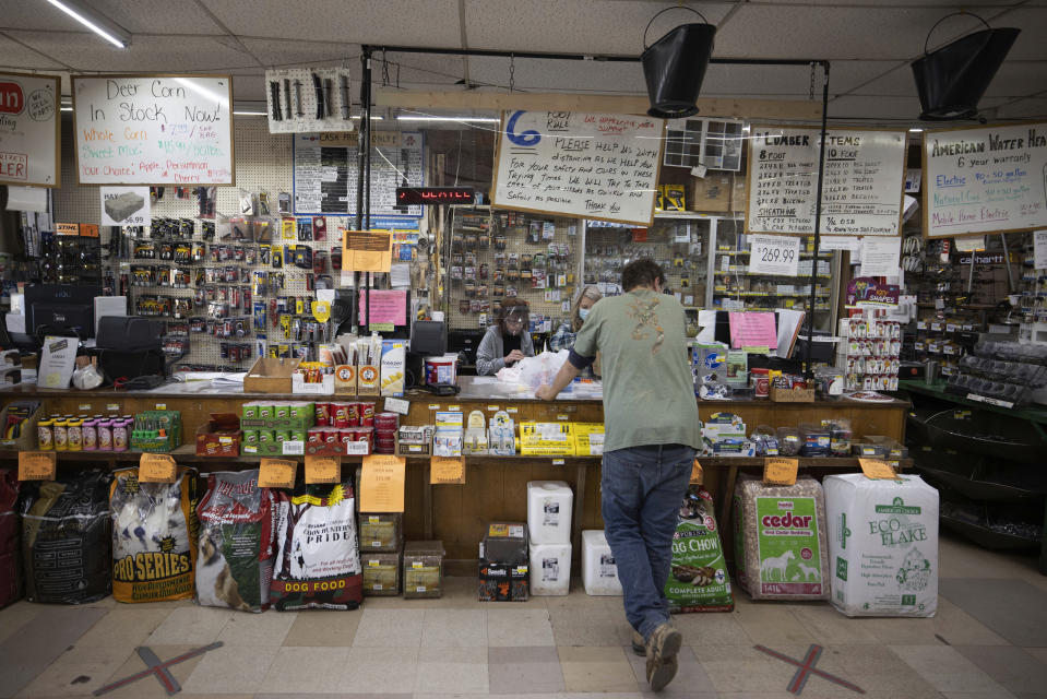 Byrnside Hardware employees Joyce Cleary and Krista White help a customer at Byrnside Hardware in Danville, W.Va., in the heart of coal country, on Tuesday, Oct. 13, 2020. Since 2014, West Virginia has lost nearly a third of its remaining full-time coal jobs as production declines. Fred Byrnside, who has run the store for 30 years, says business has fallen off. (AP Photo/Chris Jackson)