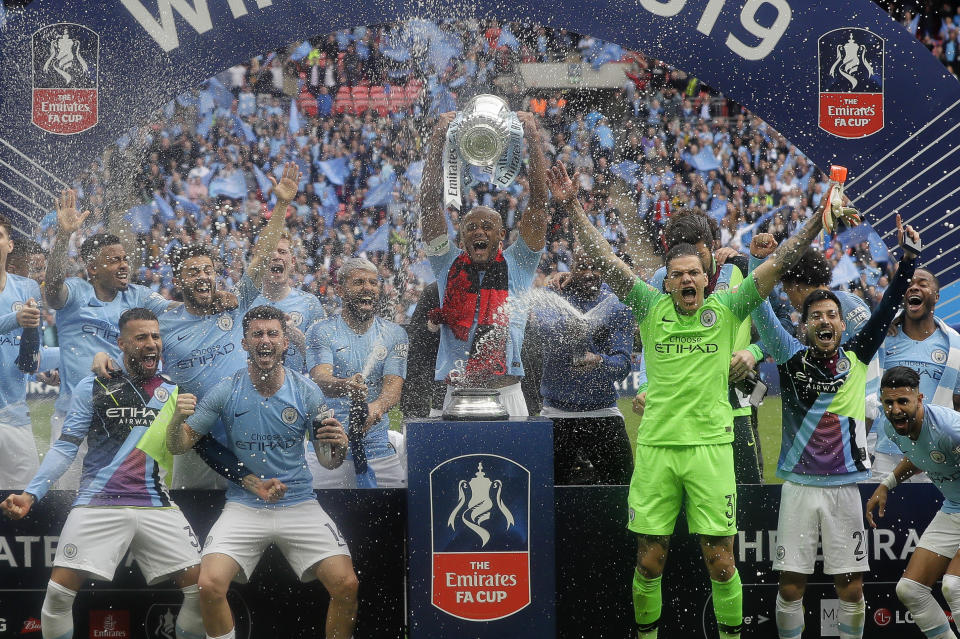 Manchester City players celebrate with the trophy after the English FA Cup Final soccer match between Manchester City and Watford at Wembley stadium in London, Saturday, May 18, 2019. (AP Photo/Kirsty Wigglesworth)