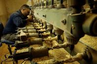 A Palestinian worker carves a figurine from olive wood to be sold during Christmas season, at a workshop in Bethlehem in the Israeli-occupied West Bank