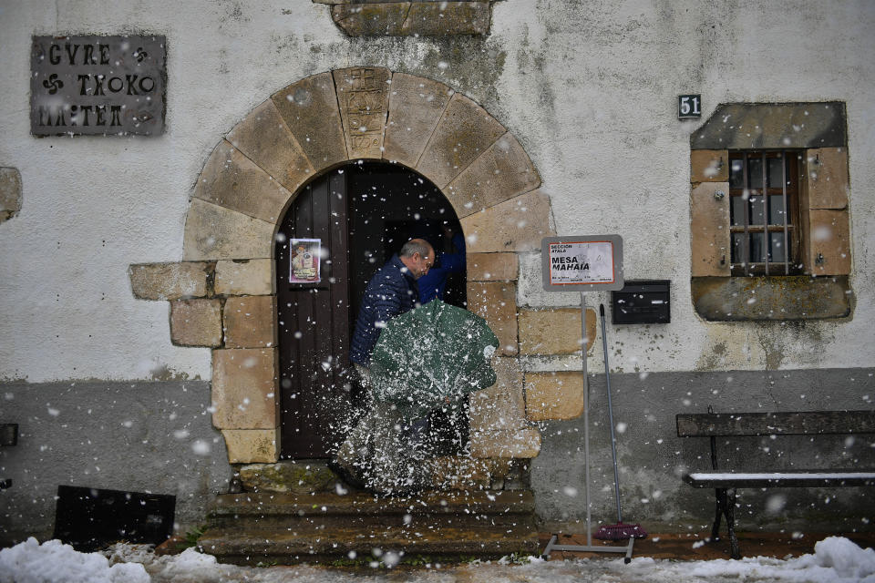 A man arrives at a polling station to cats his vote for the general election as the snow fall in the small Pyrenees village of Guerendian, northern Spain, Sunday, Nov.10, 2019. Spain holds its second national election this year after Socialist leader Pedro Sanchez failed to win support for his government in a fractured Parliament.(AP Photo/Alvaro Barrientos)