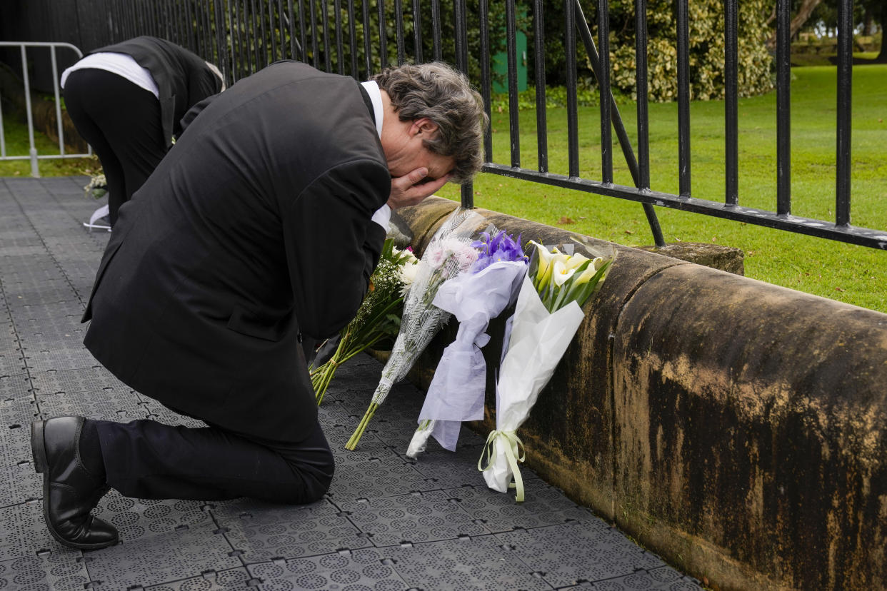 A man reacts after placing flowers outside Government House following the passing of Queen Elizabeth II in Sydney, Australia, Friday, Sept. 9, 2022. (AP Photo/Mark Baker)