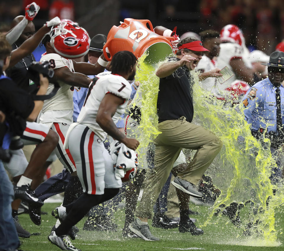 Georgia coach Kirby Smart gets doused while rushing the field with tailback D'Andre Swift and other team members after Georgia defeated Baylor 26-14 during the Sugar Bowl NCAA college football game Wednesday, Jan. 1, 2020, in New Orleans. (Curtis Compton/Atlanta Journal-Constitution via AP)