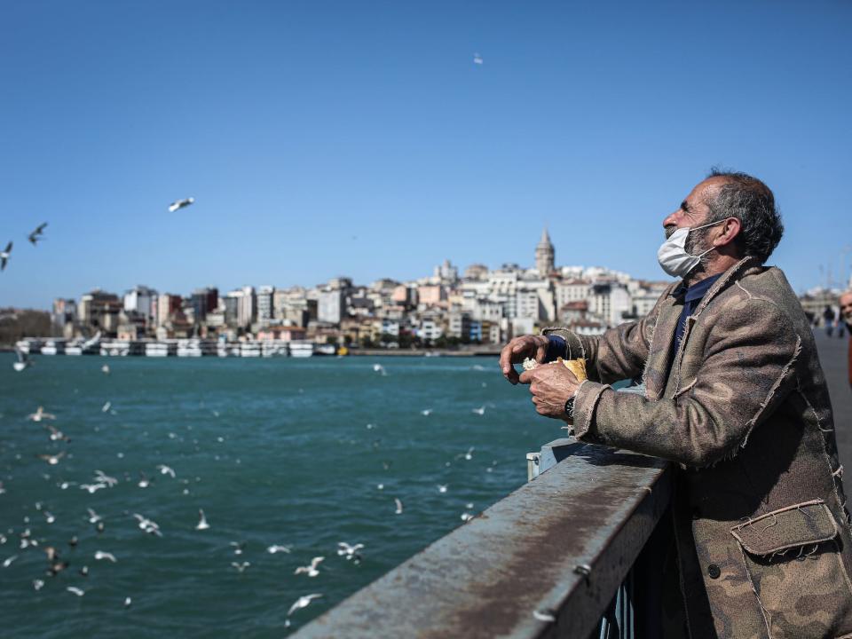 A man wearing face mask feeds seagulls from nearly empty Galata Bridge as people are staying home due to the coronavirus pandemic in Istanbul, Turkey on April 7.