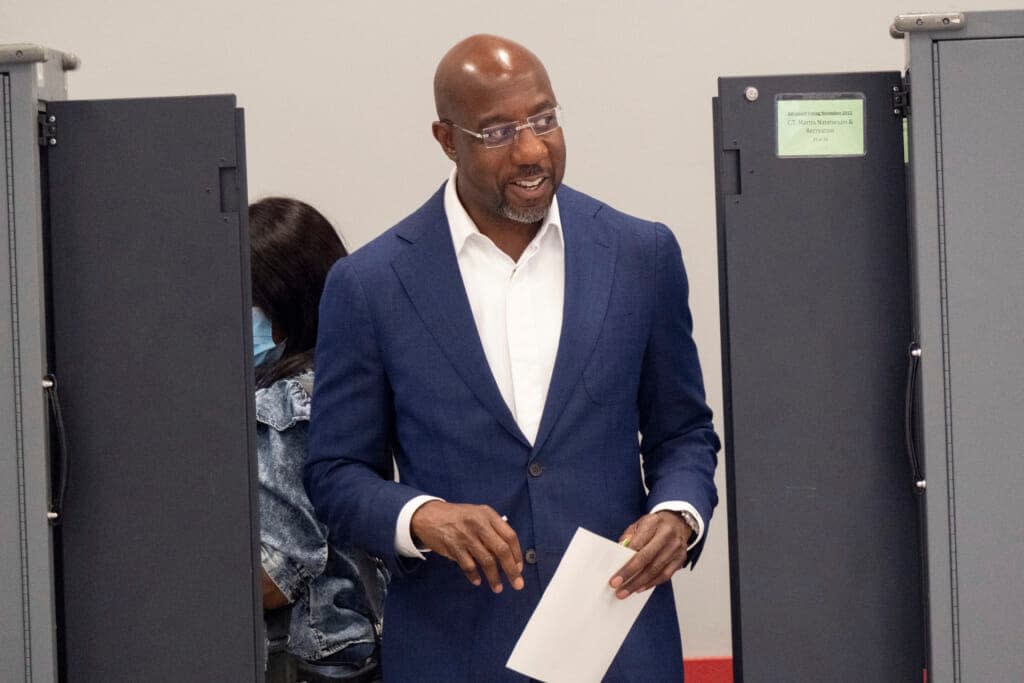 Sen. Raphael Warnock, D-Ga., walks away from a voting machine after marking his ballot on the first day of early voting in Atlanta on Monday, Oct. 17, 2022. (AP Photo/Ben Gray)