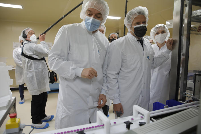 French President Emmanuel Macron, second right, and plant manager Wladimir Guitel, visit the Delpharm plant in Saint-Remy-sur-Avre, west of Paris, Friday, April 9, 2021 in Paris. The Delpharm plant started bottling Pfizer vaccines this week as France tries to make its mark on global vaccine production, and speed up vaccinations of French people amid a new virus surge. (AP Photo/Christophe Ena, Pool)