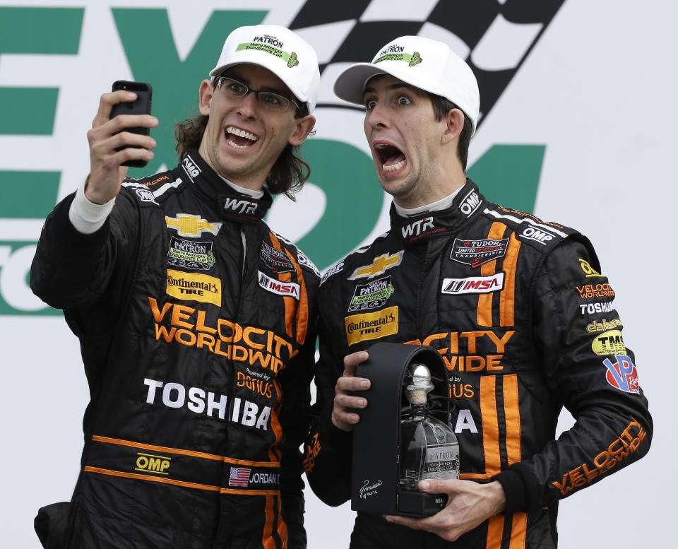 Jordan Taylor, left, and his brother Ricky Taylor take a photo of themselves in Victory Lane after they placed second in the IMSA Series Rolex 24 hour auto race at Daytona International Speedway in Daytona Beach, Fla., Sunday, Jan. 26, 2014.(AP Photo/John Raoux)