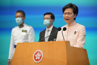 Hong Kong's Chief Executive Carrie Lam, right, speaks besides Chief Secretary John Lee, center, and Commissioner of Police Raymond Siu during a news conference in Hong Kong, Friday, June 25, 2021. China on Friday promoted Hong Kong’s top security official to the territory’s No. 2 spot as Beijing continues to clamp down on free speech and political opposition. (AP Photo/Kin Cheung)