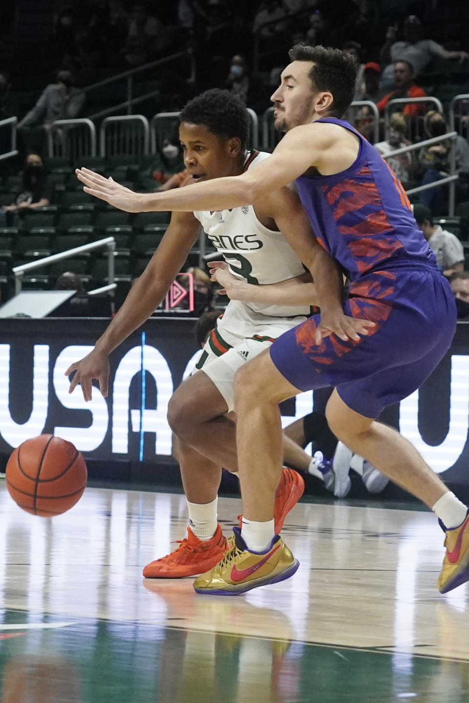 Clemson guard Alex Hemenway (12) defends Miami guard Charlie Moore (3) during the first half of an NCAA college basketball game, Saturday, Dec. 4, 2021, in Coral Gables, Fla. (AP Photo/Marta Lavandier)