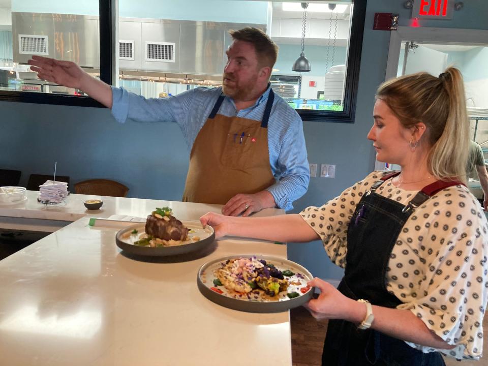 Shawn Hyer, co-owner of Bramble, tells Ashley Francis which table to deliver dinner to at the Essex restaurant May 27, 2022.