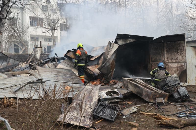 Firefighters extinguish a fire after a Russian precision munition hit civilian infrastructure in Kharkiv in north-eastern Ukraine. -/Ukrinform/dpa