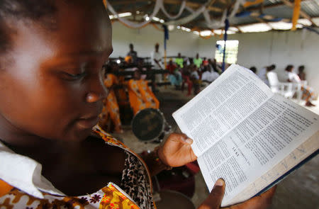 A churchgoer reads the Bible at a church where evangelist and ex-combatant Joshua Milton Blahyi preaches in Grand Gedeh, Liberia, July 3, 2016. REUTERS/Thierry Gouegnon