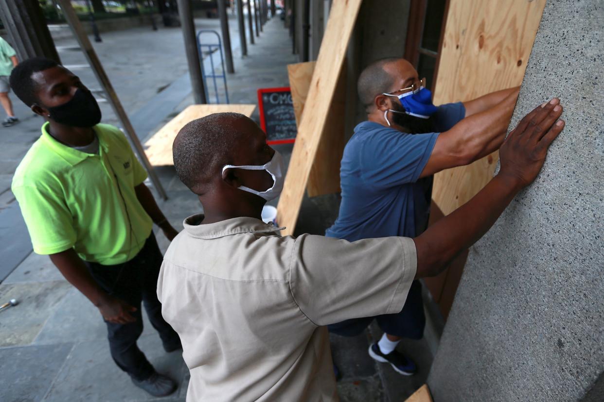 Boarding up windows in New Orleans's French Quarter in anticipation of Tropical Storms Marco and Laura: Getty Images