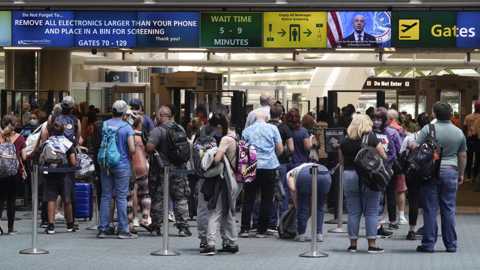 Travelers line up to go through a TSA checkpoint at Orlando International Airport before the Memorial Day weekend Friday, May 28, 2021, in Orlando, Fla. (AP Photo/John Raoux)