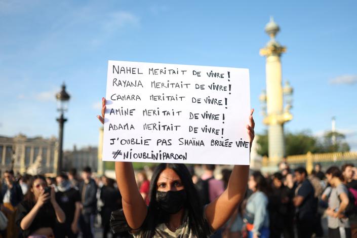 A protester holds a placard with names of victims with the quote 