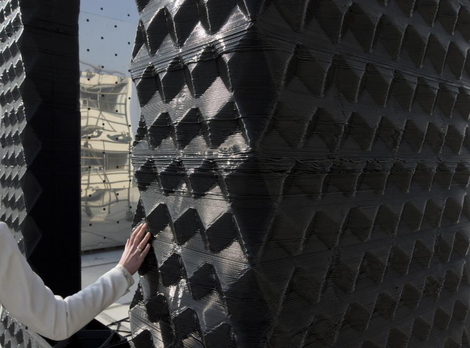 A woman touches the wallls of a canal house which was printed with a 3D printer in Amsterdam, Netherlands, Thursday, March 13, 2014. Dutch architecture firm Dus has embarked on a project to build a 21st-century version of a classic Amsterdam canal house, printing it out piece by piece with an oversized 3-D printer, and then slotting them together like oversized Lego blocks. The goal is to discover and share the potential uses of 3-D printing in construction by creating new materials, trying out designs and testing building techniques. (AP Photo/Peter Dejong)