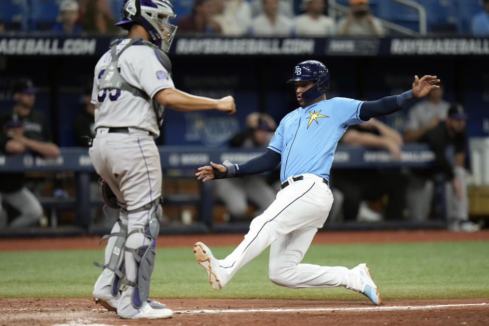 Tampa Bay Rays' Christian Bethancourt, right, scores in front of Colorado Rockies catcher Elias Diaz on an two-run single by Randy Arozarena during the eighth inning of a baseball game Tuesday, Aug. 22, 2023, in St. Petersburg, Fla. (AP Photo/Chris O'Meara)