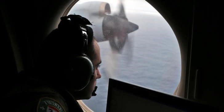 FILE PHOTO - Flight officer Rayan Gharazeddine looks out of a Royal Australian Air Force (RAAF) AP-3C Orion as it flies over the southern Indian Ocean during the search for missing Malaysian Airlines flight MH370 March 22, 2014.  REUTERS/Rob Griffith/Pool/File Photo