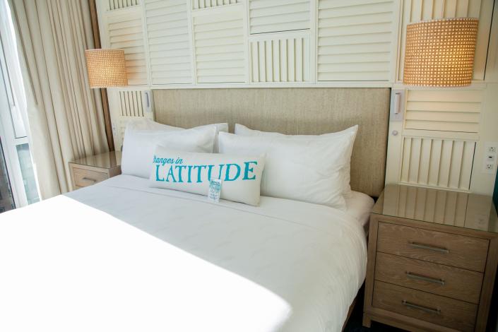 a bed with a pillow with Latitude on it