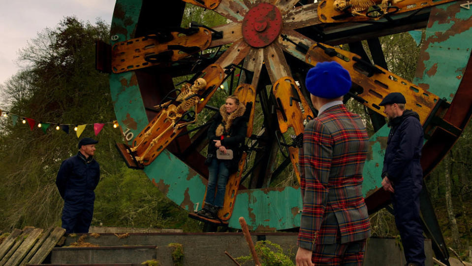 Contestants strapped to an old ferris wheel