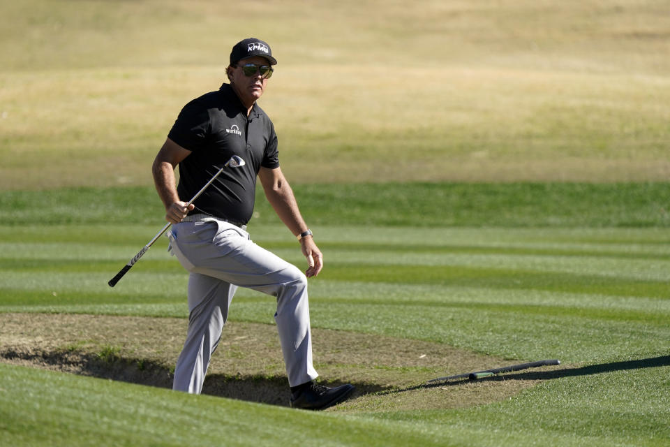 Phil Mickelson walks out from a bunker after hitting to the 17th green during the first round of The American Express golf tournament on the Nicklaus Tournament Course at PGA West Thursday, Jan. 21, 2021, in La Quinta, Calif. (AP Photo/Marcio Jose Sanchez)