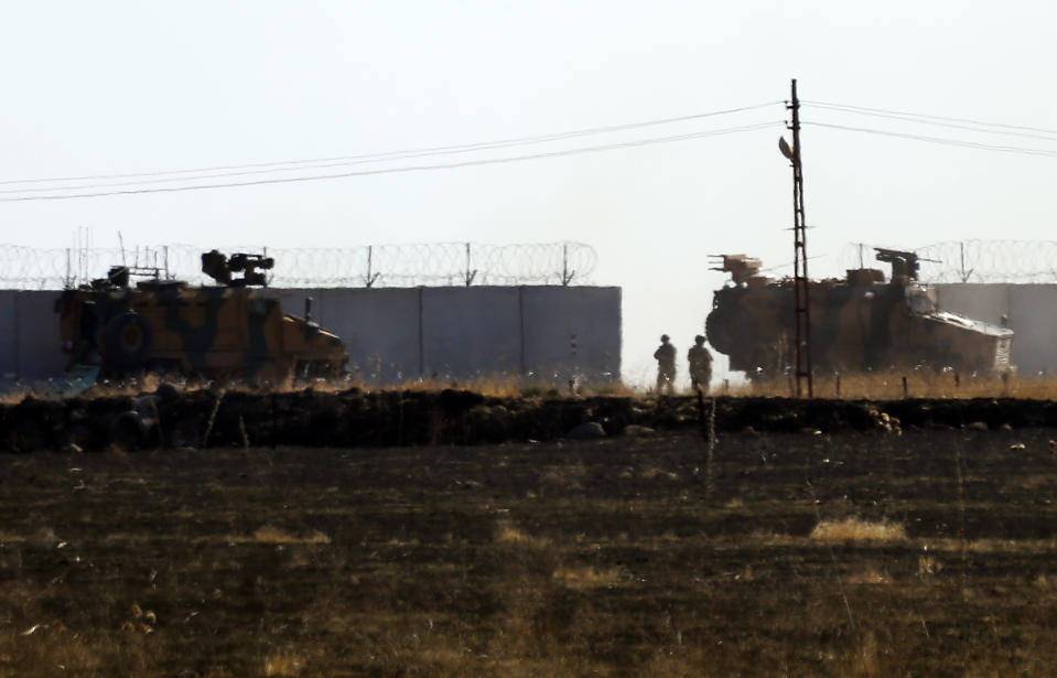 In this photo taken from the outskirts of the village of Alakamis, in Idil province, southeastern Turkey, Turkish army vehicles return to Turkey from Syria after conducting a joint patrol with Russian forces, Friday, Nov. 8, 2019. The Britain-based Syrian Observatory for Human Rights says a protester has been killed when he was run over in the village of Sarmasakh, Syria near the border by a Turkish vehicle during a joint patrol with Russia.The man was among residents who pelted with shoes and stones Turkish and Russian troops who were conducting their third joint patrol in northeastern Syria, under a cease-fire deal brokered by Moscow that forced Kurdish fighters to withdraw from areas bordering Turkey. (AP Photo/Mehmet Guzel)