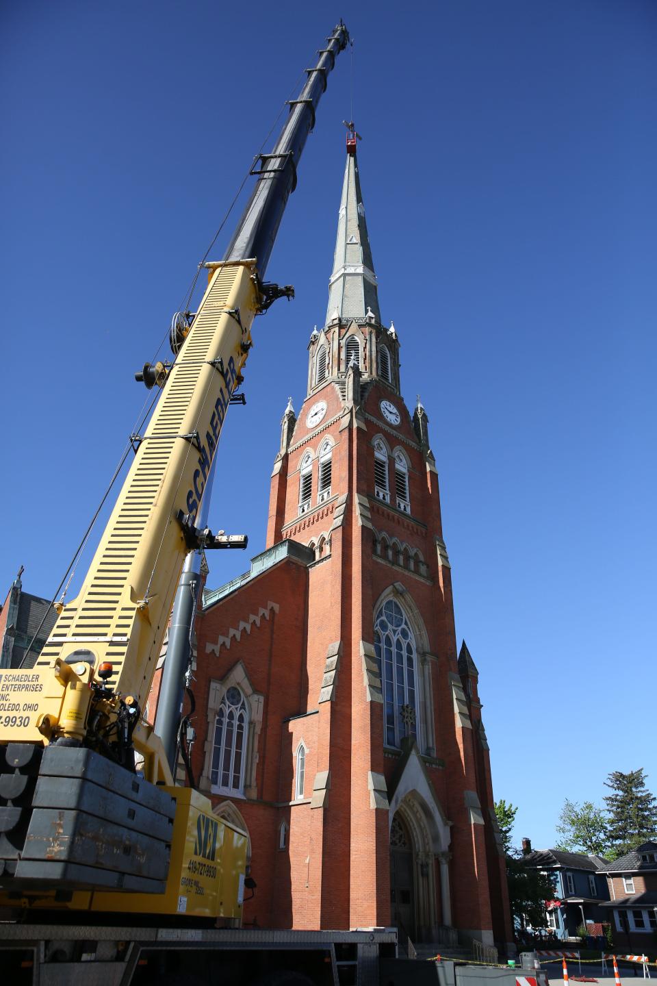 A crane from Schaedler Enterprises Inc. in Toledo, works with Detroit Steeplejack Bryan Dulsky, with much needed restoration of the Saint Joseph Catholic Church, at 709 Croghan St. in Fremont.