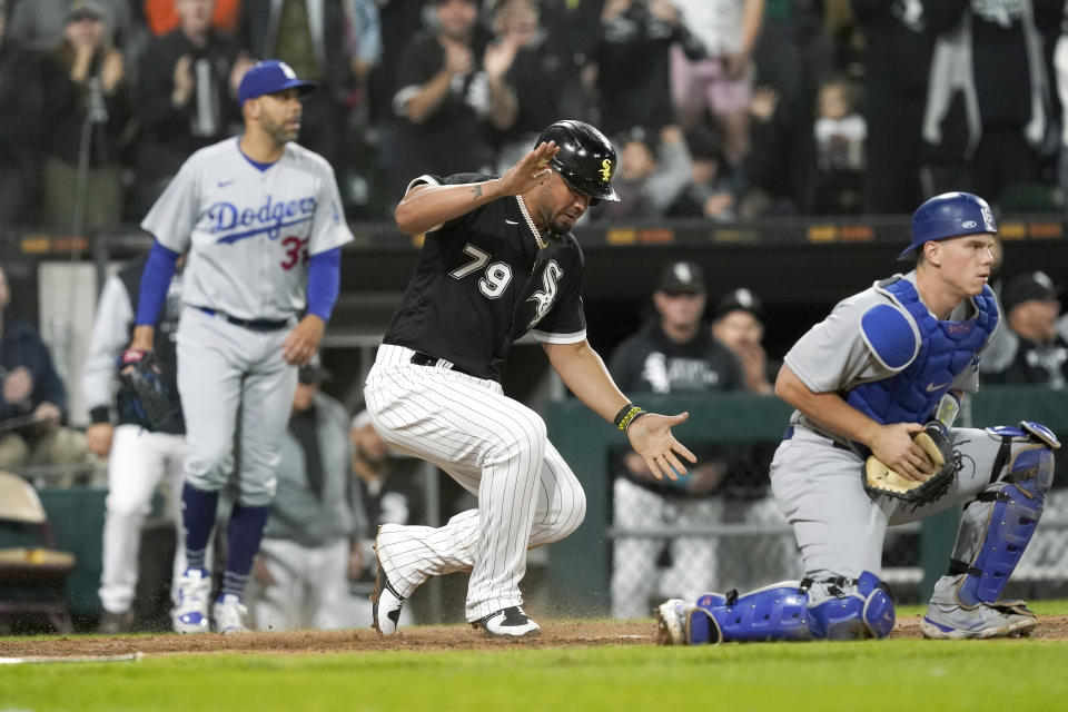 Chicago White Sox's Jose Abreu (79) begins to celebrate after scoring next to Los Angeles Dodgers catcher Will Smith during the sixth inning of a baseball game Tuesday, June 7, 2022, in Chicago. (AP Photo/Charles Rex Arbogast)