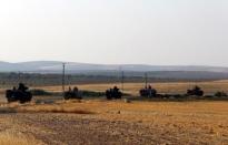 Turkish armoured personnel carriers drive towards the border in Karkamis on the Turkish-Syrian border in the southeastern Gaziantep province, Turkey, August 27, 2016. REUTERS/Umit Bektas