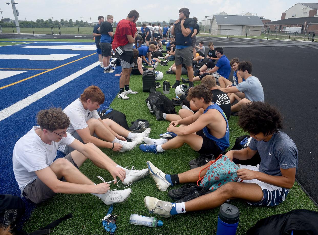 Dundee Vikings varsity and junior varsity players sit to put on their shoes to practice on the new turf field inside the new John D. Craig and Family Athletic Complex at a recent practice this past week, as many of them purchased new shoes to be broken in.  