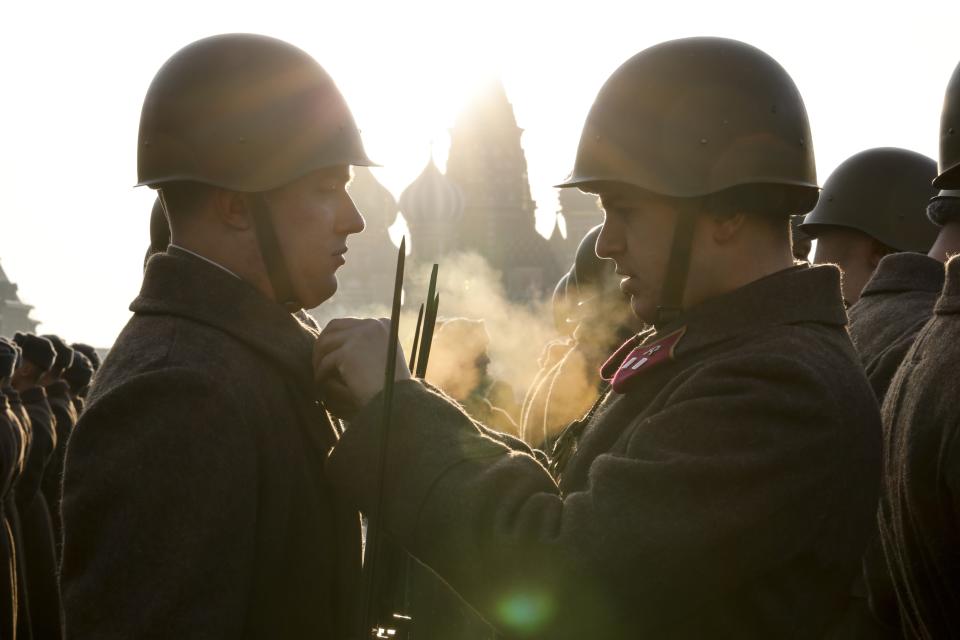 Russian soldiers dressed in Red Army World War II uniforms prepare to the start of the Nov. 7 parade in Red Square, with St. Basil Cathedral in the background, in Moscow, Russia, Wednesday, Nov. 7, 2018. The event marked the 77th anniversary of a World War II historic parade in Red Square and honored the participants in the Nov. 7, 1941 parade who headed directly to the front lines to defend Moscow from the Nazi forces. (AP Photo/Alexander Zemlianichenko)