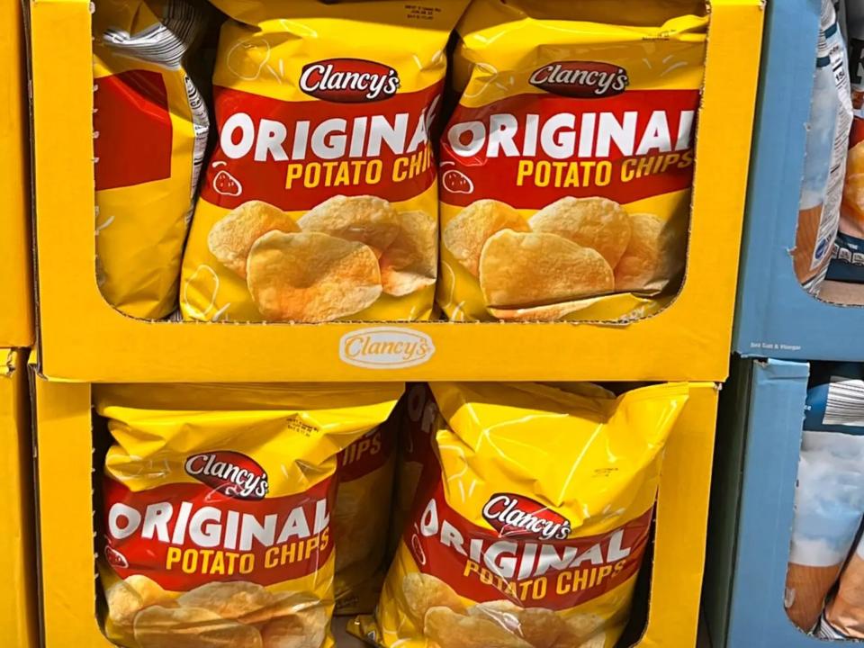 Bright-yellow bags of Clancy's chips on shelves at Aldi