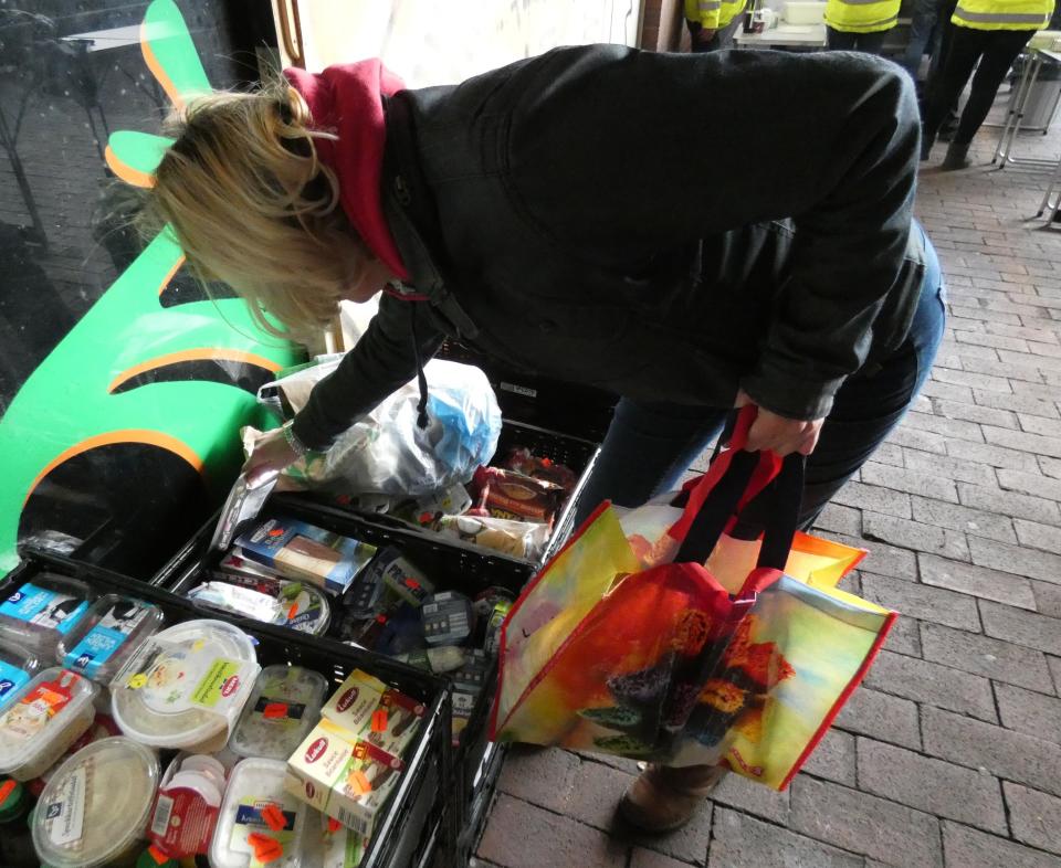 Sandra Lüke füllt die Tasche einer Frau, die nicht genug Geld hat, um ihren Lebensunterhalt zu bestreiten. (Foto: Janina Scheer)