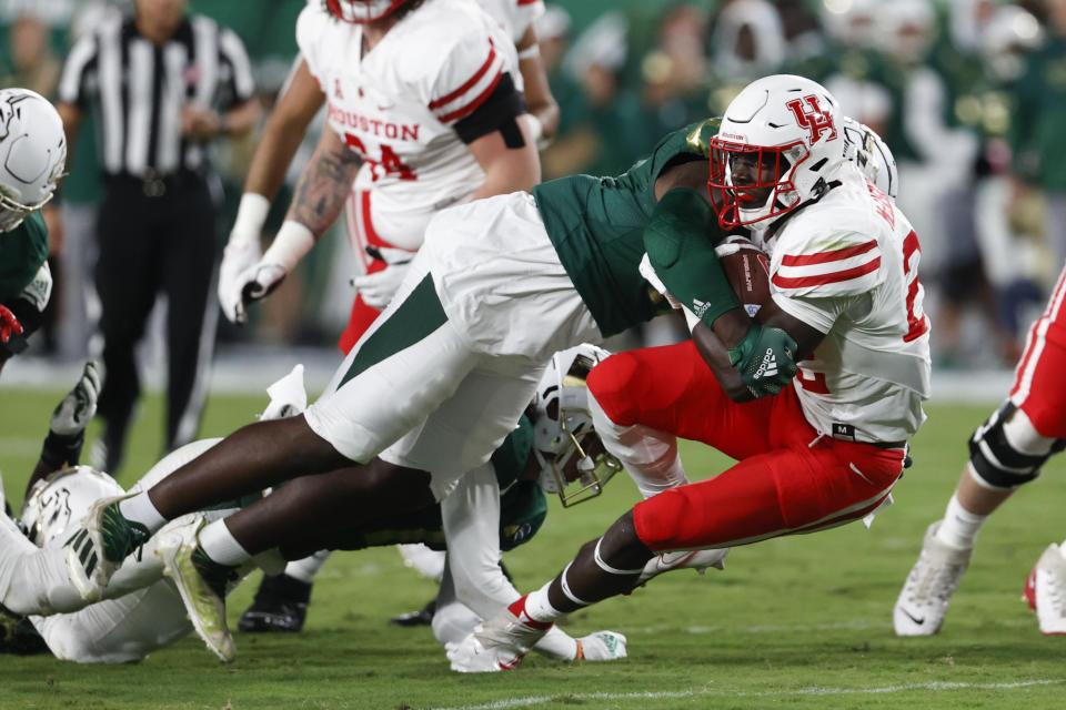 South Florida defensive tackle Blake Green tackles Houston's Alton McCaskill during the first half of an NCAA college football game Saturday, Nov. 6, 2021, in Tampa, Fla. (AP Photo/Scott Audette)