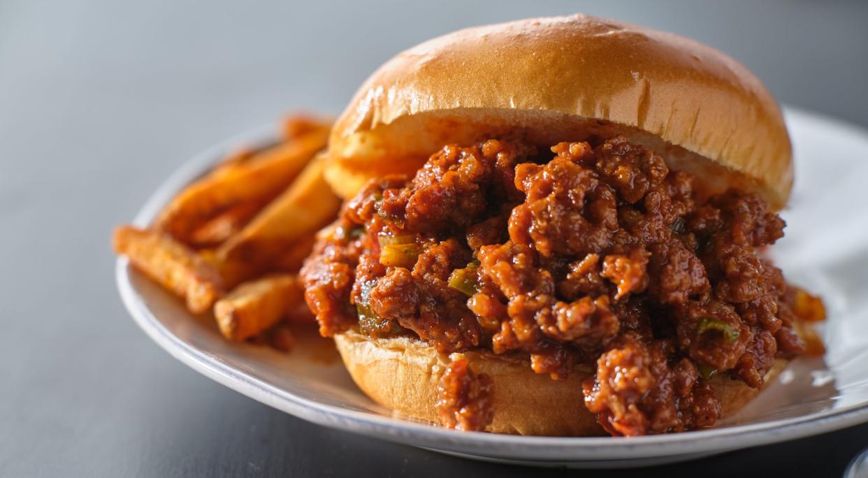 sloppy joe sandwich on plate with french fries on plate