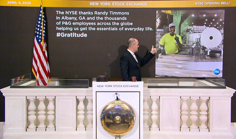 In this photo taken from video provided by the New York Stock Exchange, Chief Security Officer Kevin Fitzgibbons rings the opening bell at the NYSE, while recognizing Randy Timmons in Albany, Ga., and thousands of employees of the Proctor & Gamble Company, Thursday, April 9, 2020. (New York Stock Exchange via AP)