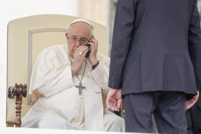 Pope Francis talks on the phone during his weekly general audience in the St. Peter's Square at the Vatican, Wednesday, May 17, 2023. (AP Photo/Andrew Medichini)