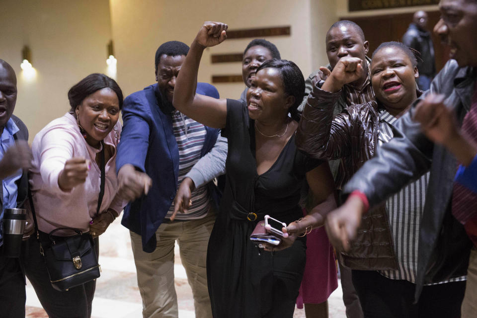 ZANU-PF supporters celebrate the victory of their candidate Emmerson Mnangagwa after Zimbabwe Electoral Commission chairwoman Qhubani Moyo announced the results of the presidential elections in Harare, Zimbabwe, Friday Aug. 3, 2018. Mnangagwa, of ZANU-PF party, was declared winner in the first vote after the fall of longtime leader Robert Mugabe. (AP Photo/Jerome Delay)