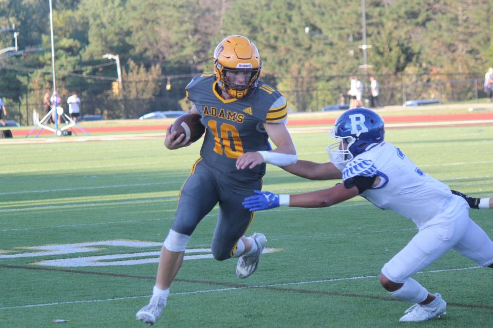 Quarterback Ryland Watters powers the Rochester Adams offense by running for a first down against Rochester High on Sept. 1 in a game played at Adams.