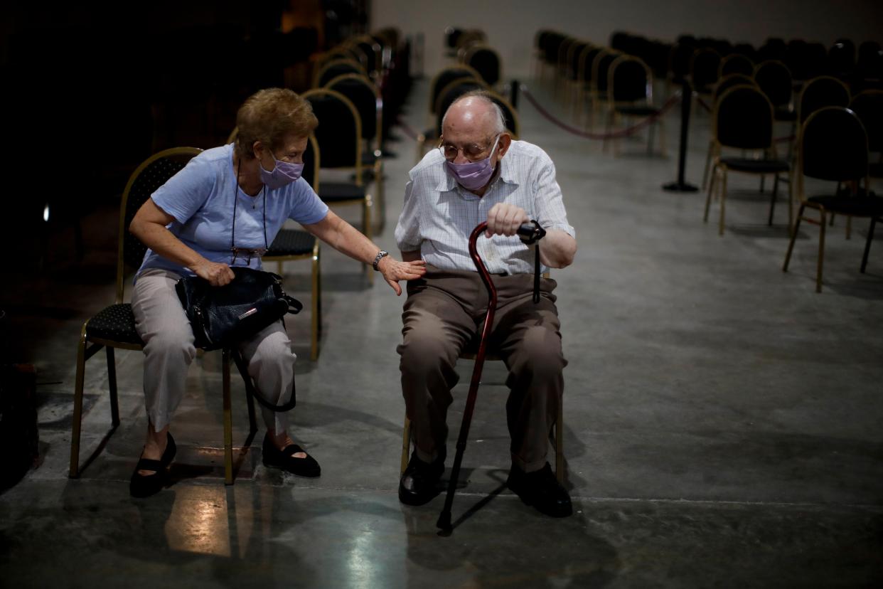 Marta Galmariz Levy sits with her husband Víctor Levy, 86, as he waits to get a shot of the AstraZeneca vaccine for COVID-19 in Buenos Aires, Argentina on Wednesday, Feb. 24, 2021, as the capital vaccinates people over the age of 80 for the new coronavirus.