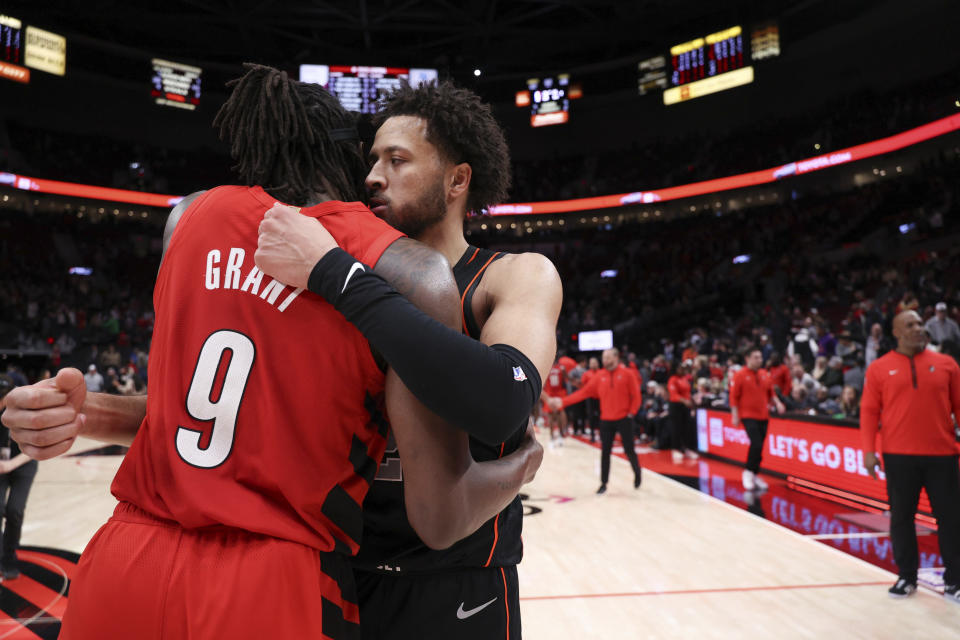 Detroit Pistons guard Cade Cunningham, right, hugs Portland Trail Blazers forward Jerami Grant at the end of an NBA basketball game Thursday, Feb. 8, 2024, in Portland, Ore. (AP Photo/Howard Lao)