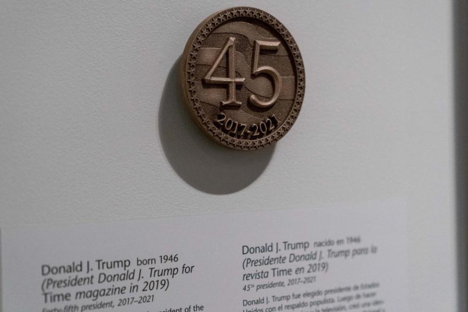 A bronze-looking emblem with the number 45 is visible next to the photo of Trump.