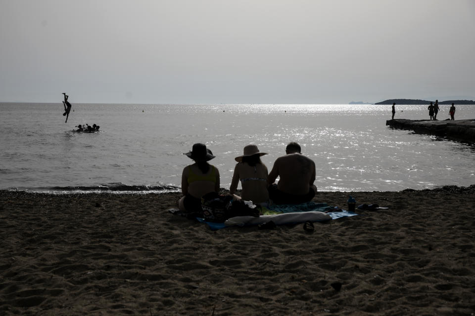 FILE - In this file photo dated Tuesday, June 22, 2021, people on a beach of Kavouri near Athens, Greece. There is guarded optimism about tourists returning in 2021, and according to the World Travel and Tourism Council, international travel is key to economic recovery for countries like Greece and Italy that rely more heavily on it. (AP Photo/Yorgos Karahalis)