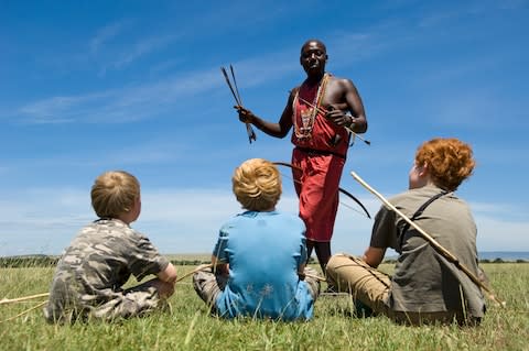 A safari guide in Kenya shows different tips on his Maasai arrows to boys on safari - Credit: GEtty